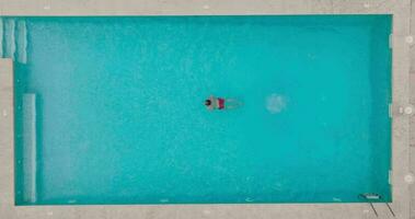 Aerial view as a man dives into the pool and swims. video