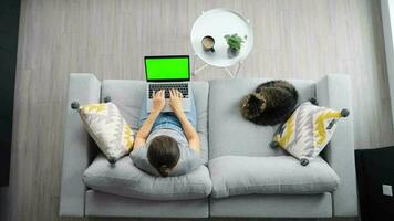 Overhead shot of woman using laptop with green mock-up screen video