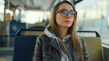 Public transport. Woman in glasses in tram using smartphone, slow motion video