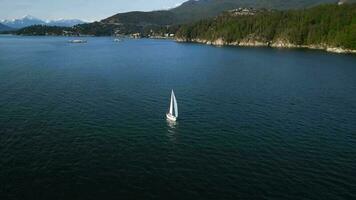 Aerial orbit view of a boat sailing along the coast at sunset. video