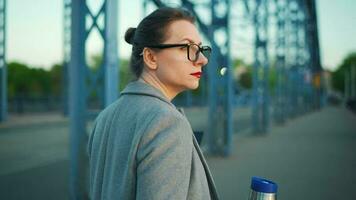 Woman in a coat, walking around the city in the early morning, drinking coffee video