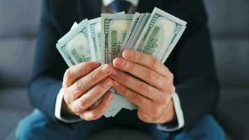 Formally dressed man counting US Dollar bills, close-up. video