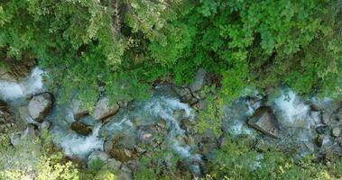 Top down view a mountain river flowing among large stones video