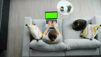 Overhead shot of woman using laptop with green mock-up screen video