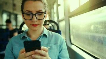 Öffentlichkeit Transport. Frau im Brille im Straßenbahn mit Smartphone. schleppend Bewegung video
