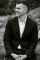 portrait of a young guy groom in a dark wool suit photo