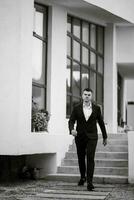 portrait of a young guy groom in a dark wool suit photo