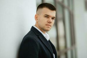 portrait of a young guy groom in a dark wool suit photo