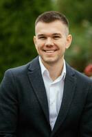 portrait of a young guy groom in a dark wool suit photo