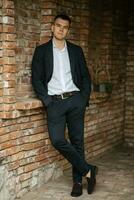 portrait of a young guy groom in a dark wool suit photo