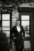 portrait of a young guy groom in a dark wool suit photo