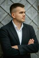 portrait of a young guy groom in a dark wool suit photo