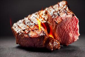 Beef steak on table with flames on dark background. Food and cuisine concept. photo