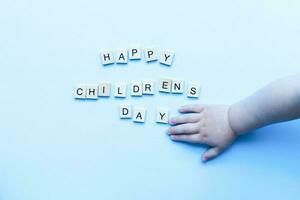 Flat lay happy childrens day on blue background. Childrens hand. Children Protection Day photo