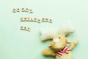 Flat lay Children is Day. Soft toy deer. Children is Day from wooden letters photo