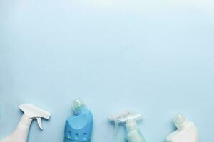 limpieza herramienta Bosquejo. plano laico limpieza productos en un azul antecedentes. aerosoles y botellas para limpieza foto