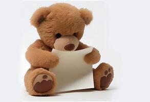 cute brown teddy bear with a sheet of paper. photo