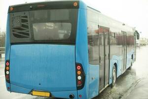 autobús en la carretera. azul autobús tira lejos desde estación. foto