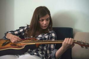 un Adolescente niña jugando guitarra foto