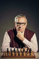 A senior man playing chess photo
