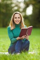 un mujer gasto hora al aire libre y leyendo un libro foto