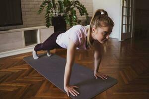 Young woman practicing pilates and yoga exercises at home photo