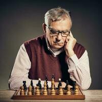 A senior man playing chess photo