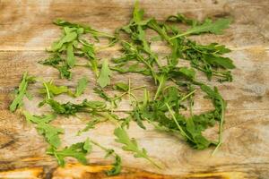 Arugula herb prepared on wooden board photo