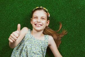 Little girl is lying on artificial grass photo