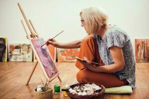 A senior woman painting photo