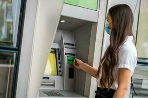 A woman using an ATM photo