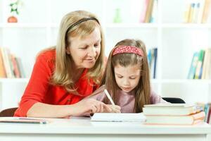 A little girl learning with her grandmother photo