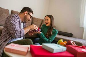 Couple exchanging gifts in their home photo