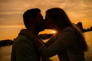 un joven Pareja terminado el puesta de sol foto