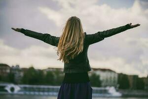 A happy young woman with open arms in the city photo