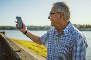 Senior man holding the phone outside photo