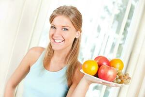 joven rubia mujer con Fruta para salud y bienestar concepto foto