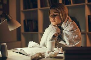 Tired college girl studying late night at home with the flu photo