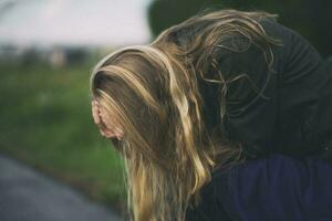 A young woman is upset and crying outdoors photo