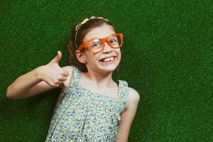 Little girl is lying on artificial grass photo