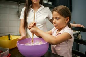 madre e hija cocinando juntas foto