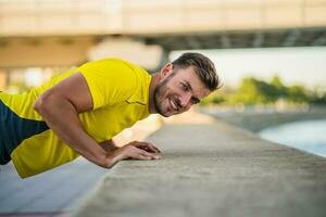 un hombre en un amarillo camiseta haciendo físico ejercicios foto