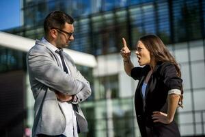 Business colleagues are arguing outside the company building. photo