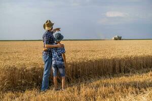 padre y hijo son en pie en su trigo campo foto