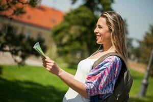 Happy young tourist woman with a map photo