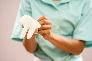 un enfermero es poniendo quirúrgico guantes en su manos foto
