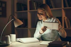 Young blonde woman studying at night photo