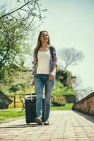 Young tourist woman carrying a suitcase photo