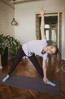 joven mujer practicando pilates y yoga ejercicios a hogar foto