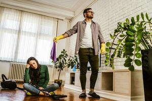 Young couple is exhausted from cleaning their apartment photo